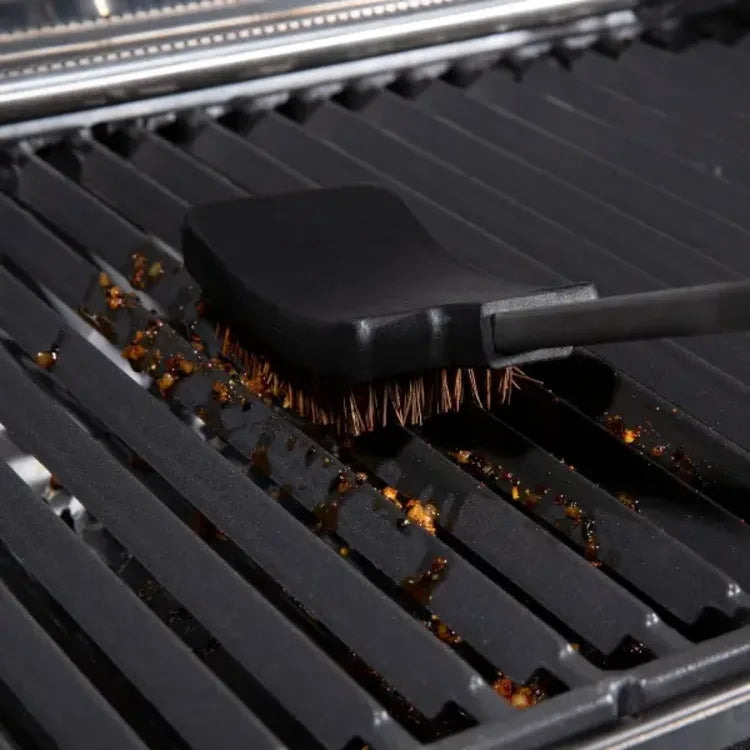 Broil King 64038, brush head resting on dirty grill grates from the side