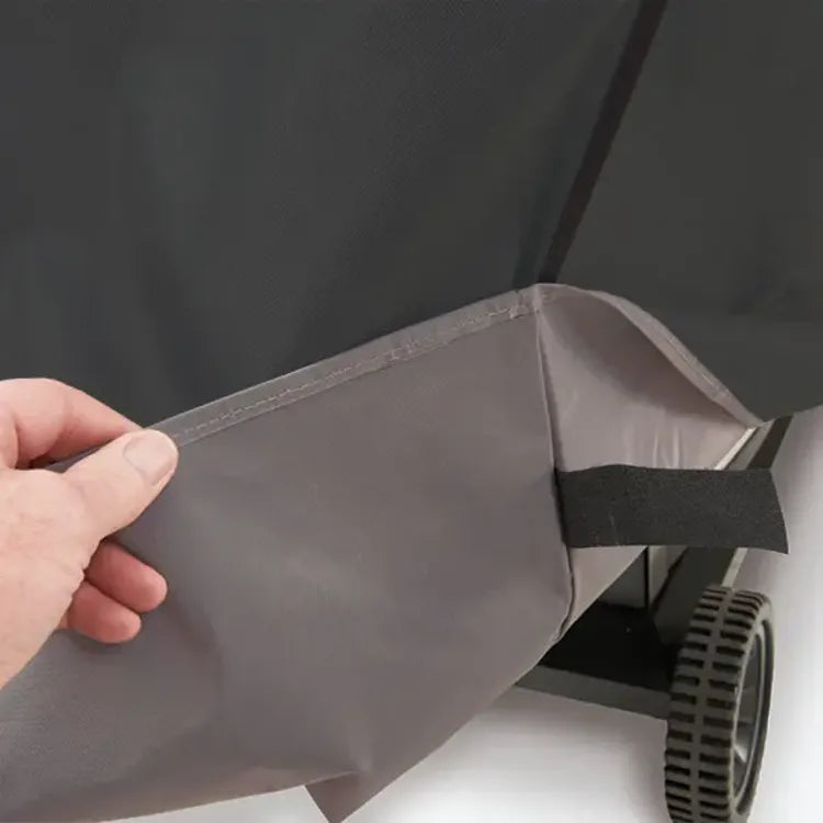 Broil King Select 67470 Grill Cover in Black, hand lifting the grey lining at the hem