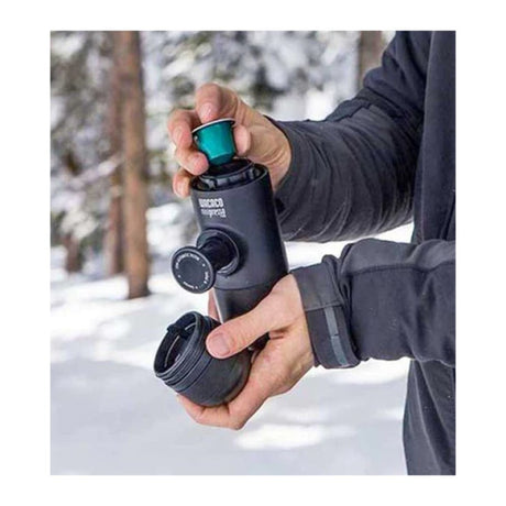 Wacaco Minipresso NS Portable Espresso Maker, held outdoors in the snow