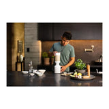 Beast Mighty B85MH Personal Blender in Cloud White, man preparing ingredients at a kitchen counter with the blender