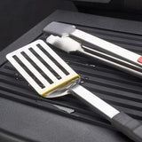 Broil King 60009 in Black, close-up of ribbed surface with spatula and tongs
