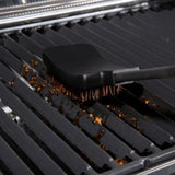 Broil King 64038, brush head resting on dirty grill grates from the side