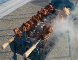 Cyprus BBQ charcoal rotisserie (foukou) grill in use, meat skewers over hot charcoal close-up