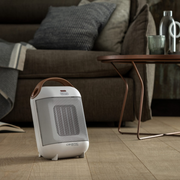 De'Longhi Capsule HFX30C18.IW Fan Heater in Ivory and White with a ceramic heating element and carry handle.