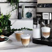 De'Longhi Magnifica Plus ECAM320.70.TB automatic coffee machine in titanium black featuring a 3.5-inch touch screen and milk carafe.