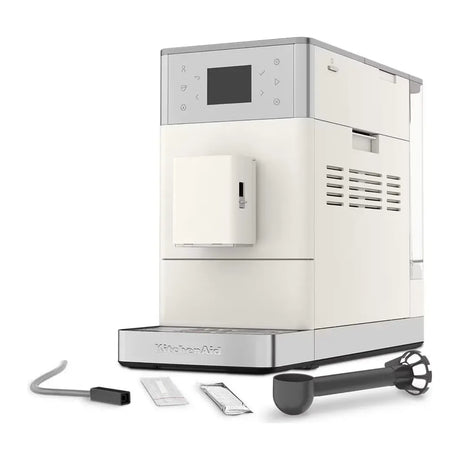 KitchenAid 5KES8453B in Porcelain White, angled view with hose, scoop and sachets laid out