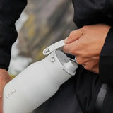 LARQ PureVis in Granite White, hand lifting the handle on the bottle lid