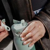 LARQ PureVis in Eucalyptus Green, hands detaching the handle from the bottle lid