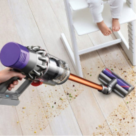 Dyson Cyclone V10 Absolute Cordless Vacuum Cleaner in Copper/Nickel, cleaning a wooden floor